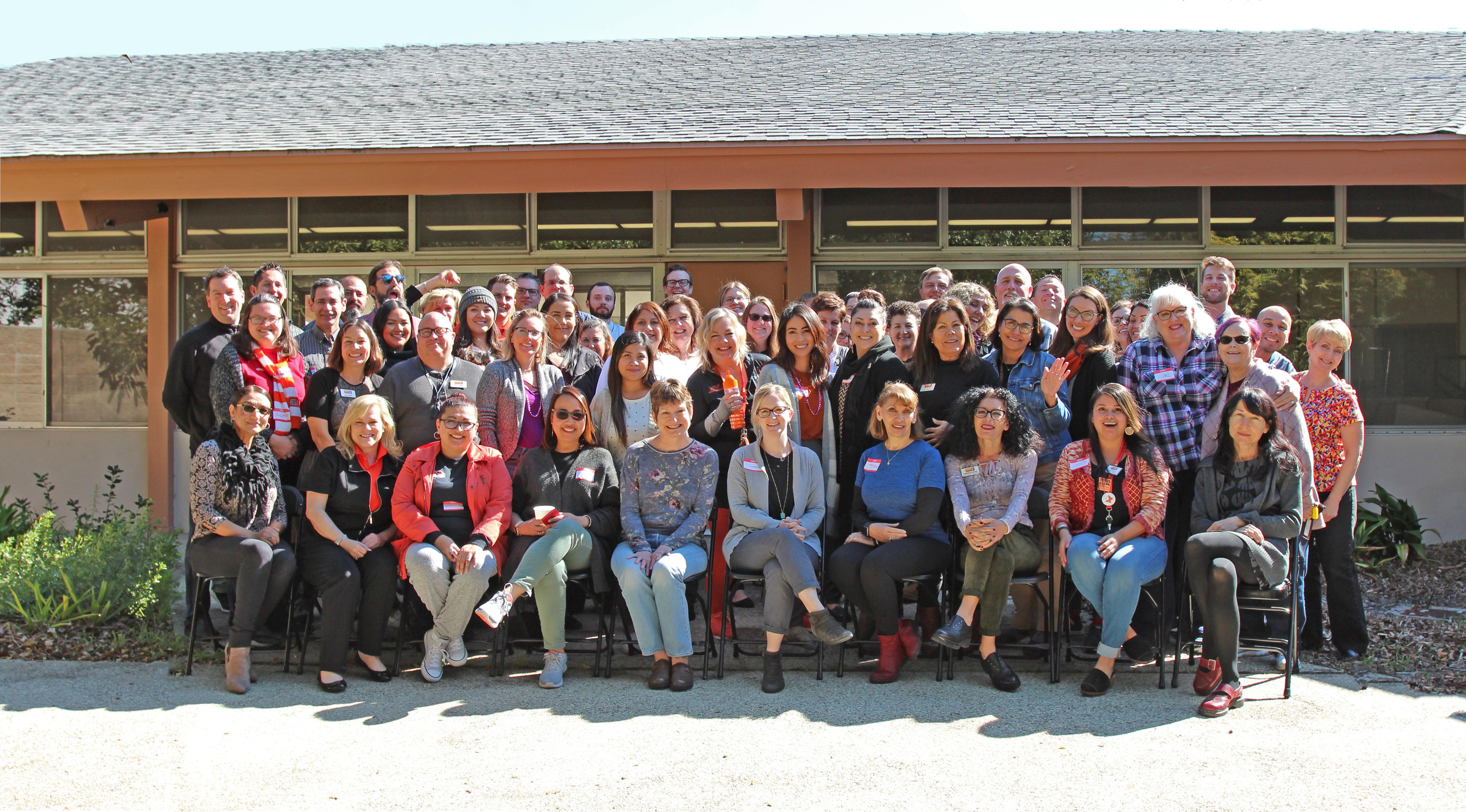 Group Photo of Ventura College staff at college wide even in the patio of Wright Event Center. The sun is shinning.