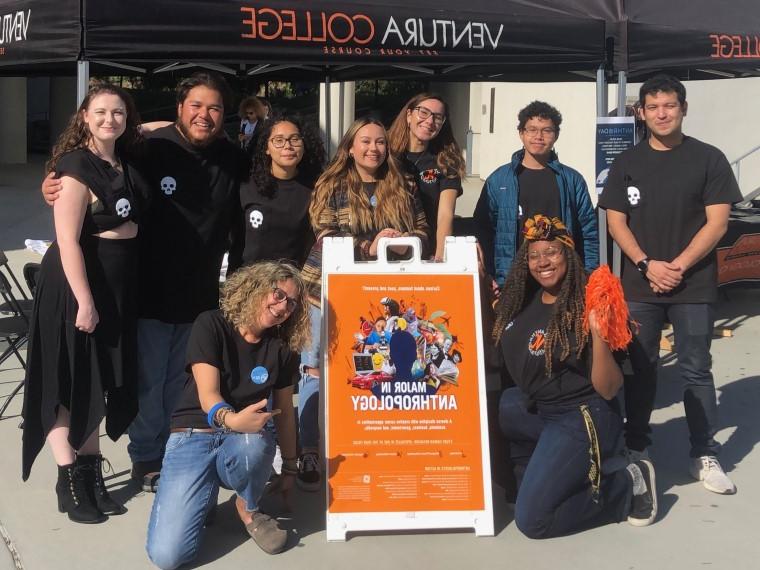 Anthropology club members with advisor in front of tent booth at club tabling event